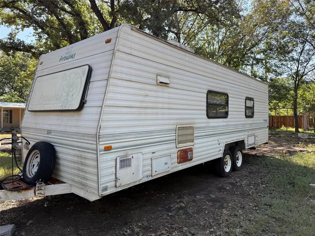 a view of a white house with a big yard and large tree