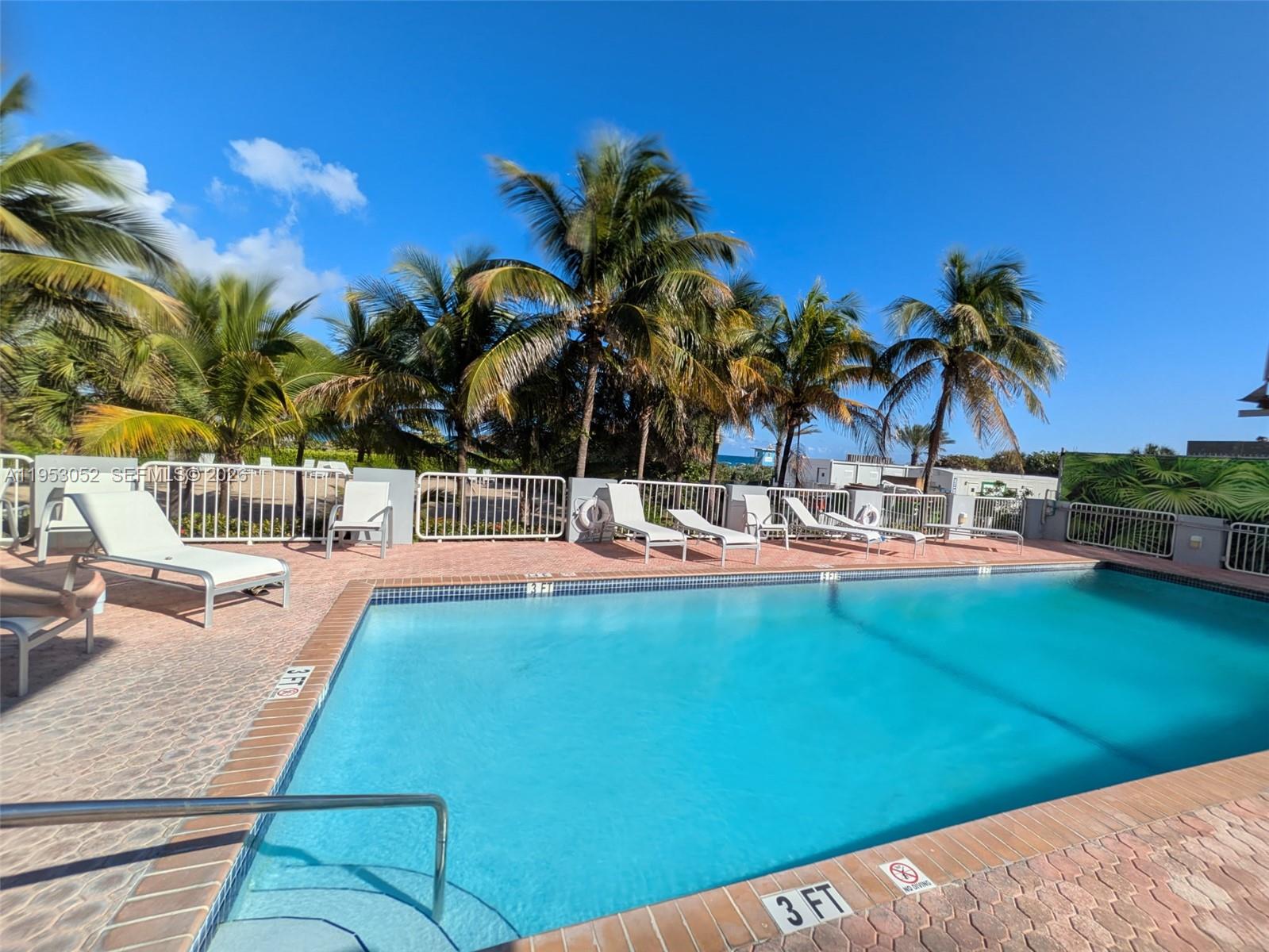 9341 Collins Avenue, Unit 503 Surfside, FL 33154 - Photo 23 of 35 a view of swimming pool with a table and chairs