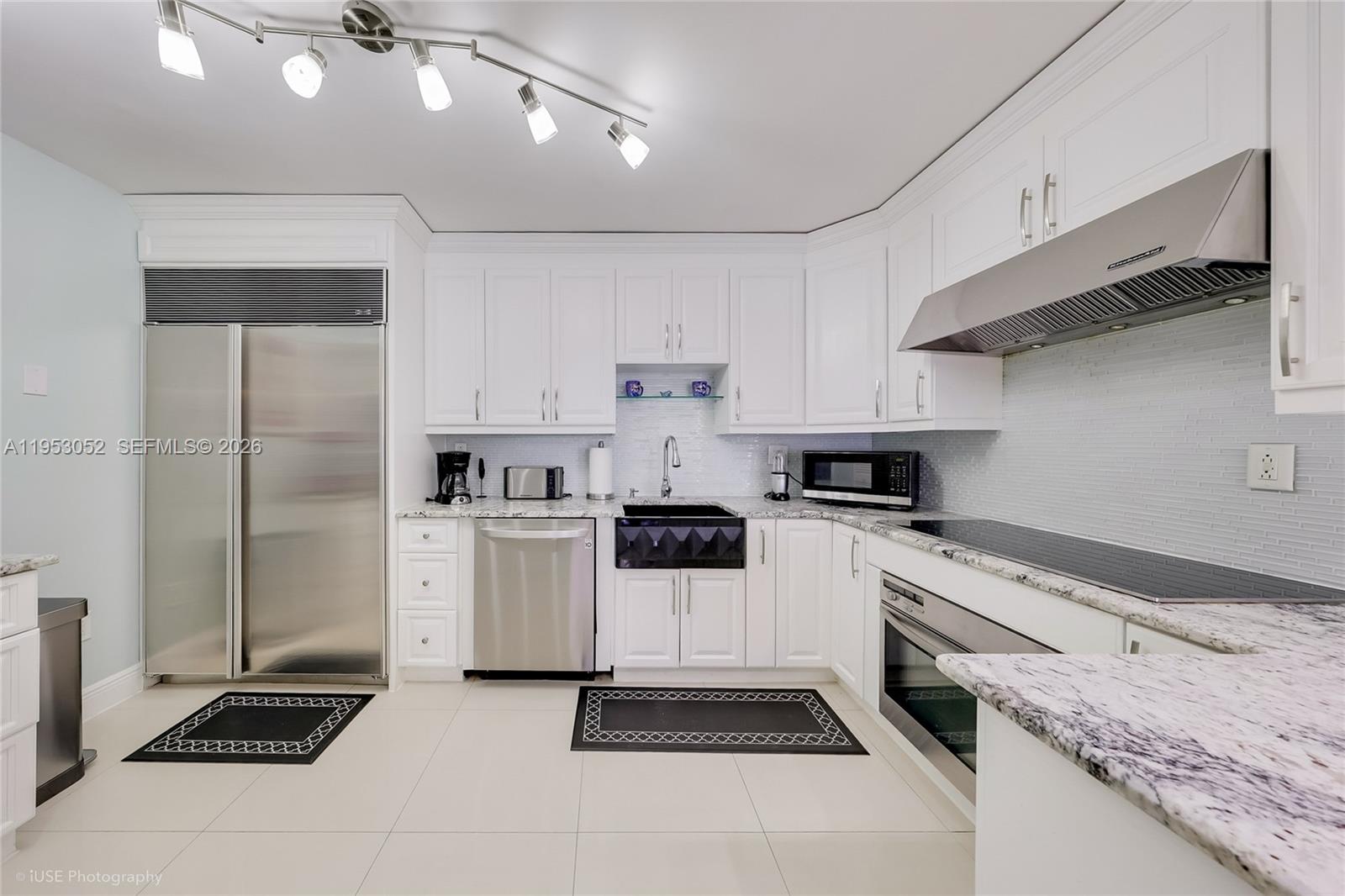 9341 Collins Avenue, Unit 503 Surfside, FL 33154 - Photo 10 of 35 a kitchen with a stove cabinets and refrigerator