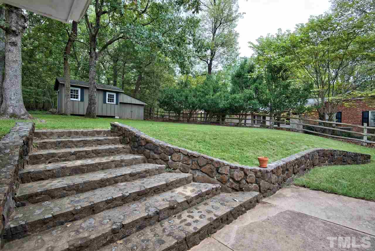 208 Latta Road Durham, NC 27712 - Photo 23 of 25 The Patio and steps lead to the backyard and storage/workshops.