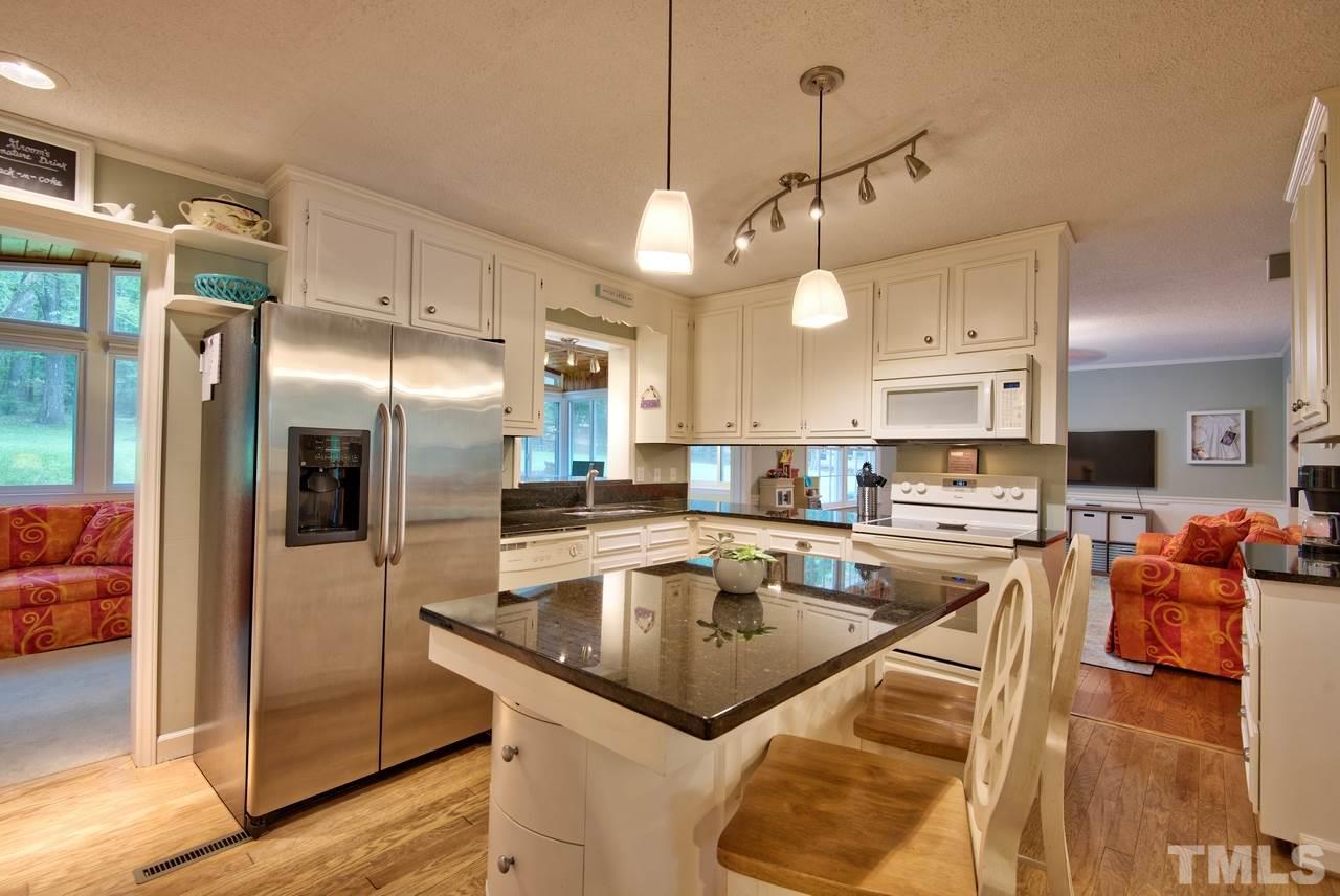 208 Latta Road Durham, NC 27712 - Photo 8 of 25 The Kitchen has a inviting feel with granite countertops, island and ample storage.