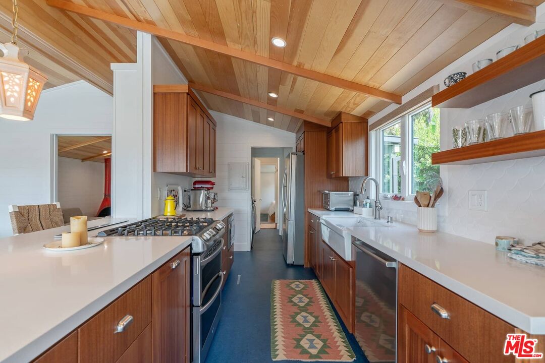 249 Paradise Cove Road Malibu, CA 90265 - Photo 13 of 41 a kitchen with a sink stove and cabinets