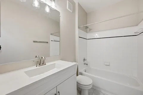 a bathroom with a sink toilet vanity and shower