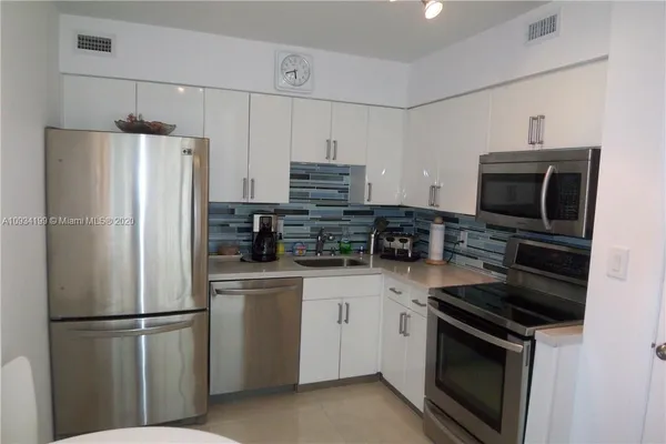 a kitchen with stainless steel appliances a refrigerator stove and microwave