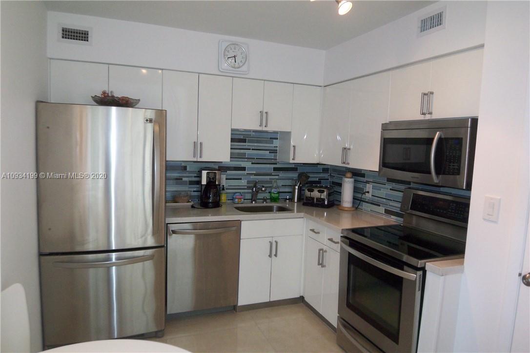 5161 Collins Avenue, Unit 806 Miami Beach, FL 33140 - Photo 12 of 52 a kitchen with stainless steel appliances a refrigerator stove and microwave