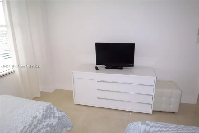a bedroom with a bed and flat screen tv