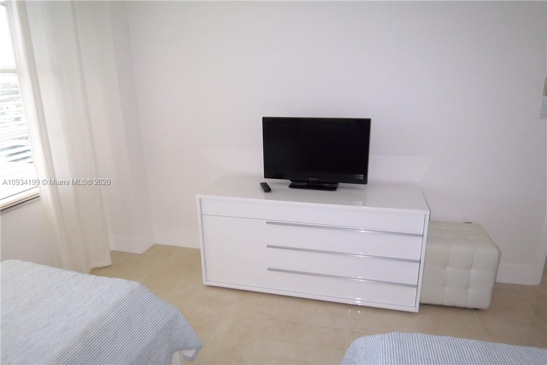 5161 Collins Avenue, Unit 806 Miami Beach, FL 33140 - Photo 16 of 52 a bedroom with a bed and flat screen tv
