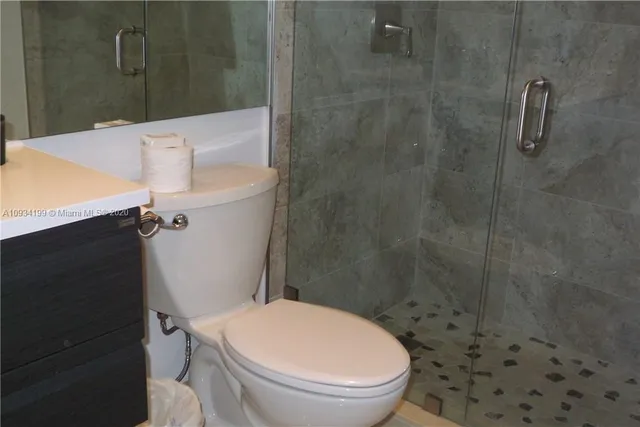 a white toilet sitting next to a bath tub