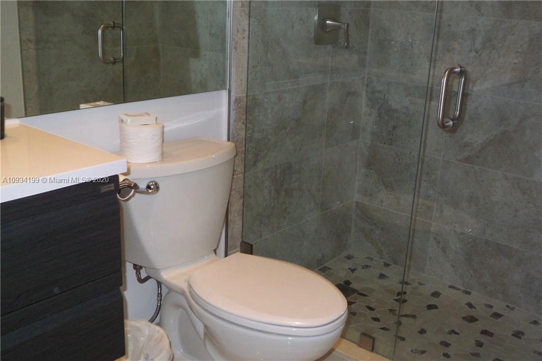 5161 Collins Avenue, Unit 806 Miami Beach, FL 33140 - Photo 20 of 52 a white toilet sitting next to a bath tub