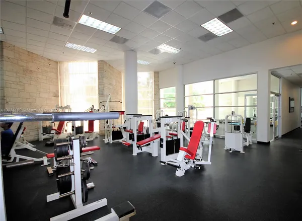 an empty room with floor to ceiling window and wooden floor