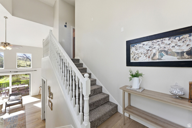 7935 Mustang Loop Road Park City, UT 84098 - Photo 39 of 60 Staircase with white balusters and carpeted treads, featuring wood-finish flooring extending into the lower-level living area