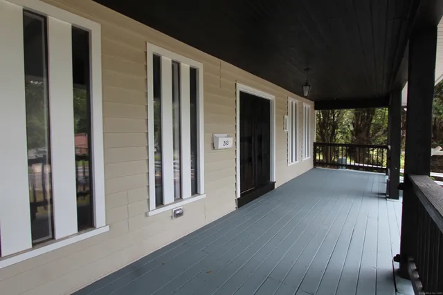 a view of a porch with wooden floor and a floor to ceiling window