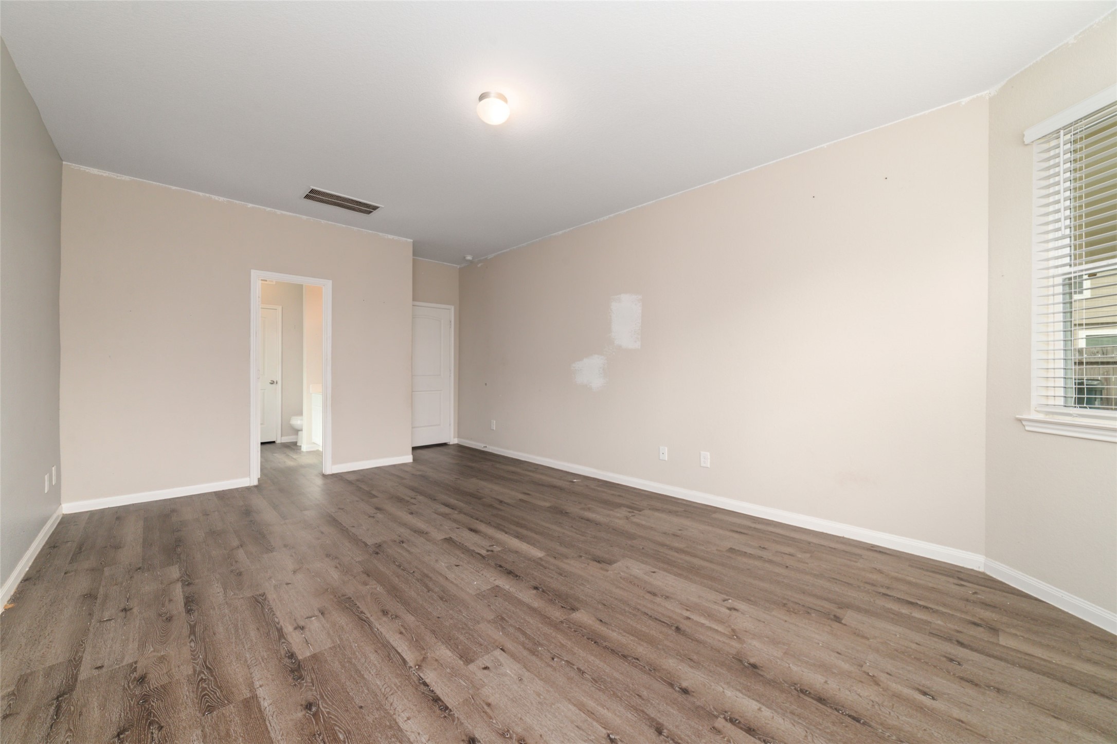 2209 Raider Drive Conroe, TX 77301 - Photo 15 of 27 an empty room with wooden floor and windows
