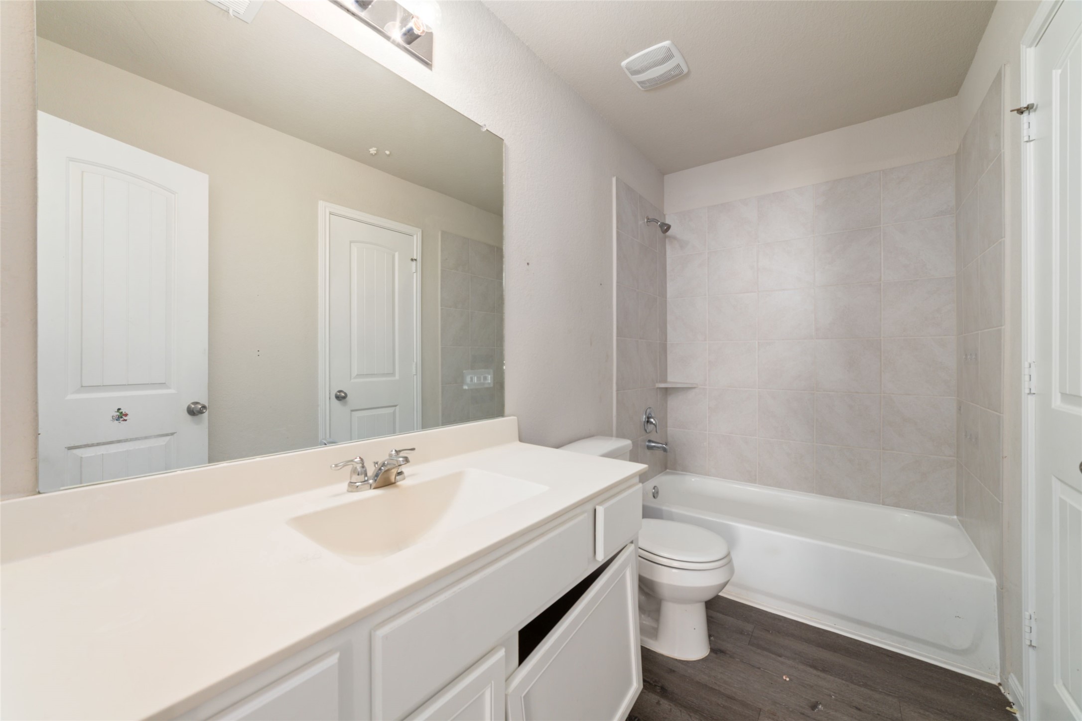 2209 Raider Drive Conroe, TX 77301 - Photo 20 of 27 a bathroom with a granite countertop sink toilet a large mirror a bathtub and shower