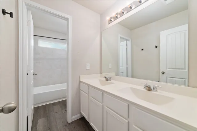 a bathroom with a tub a sink and mirror
