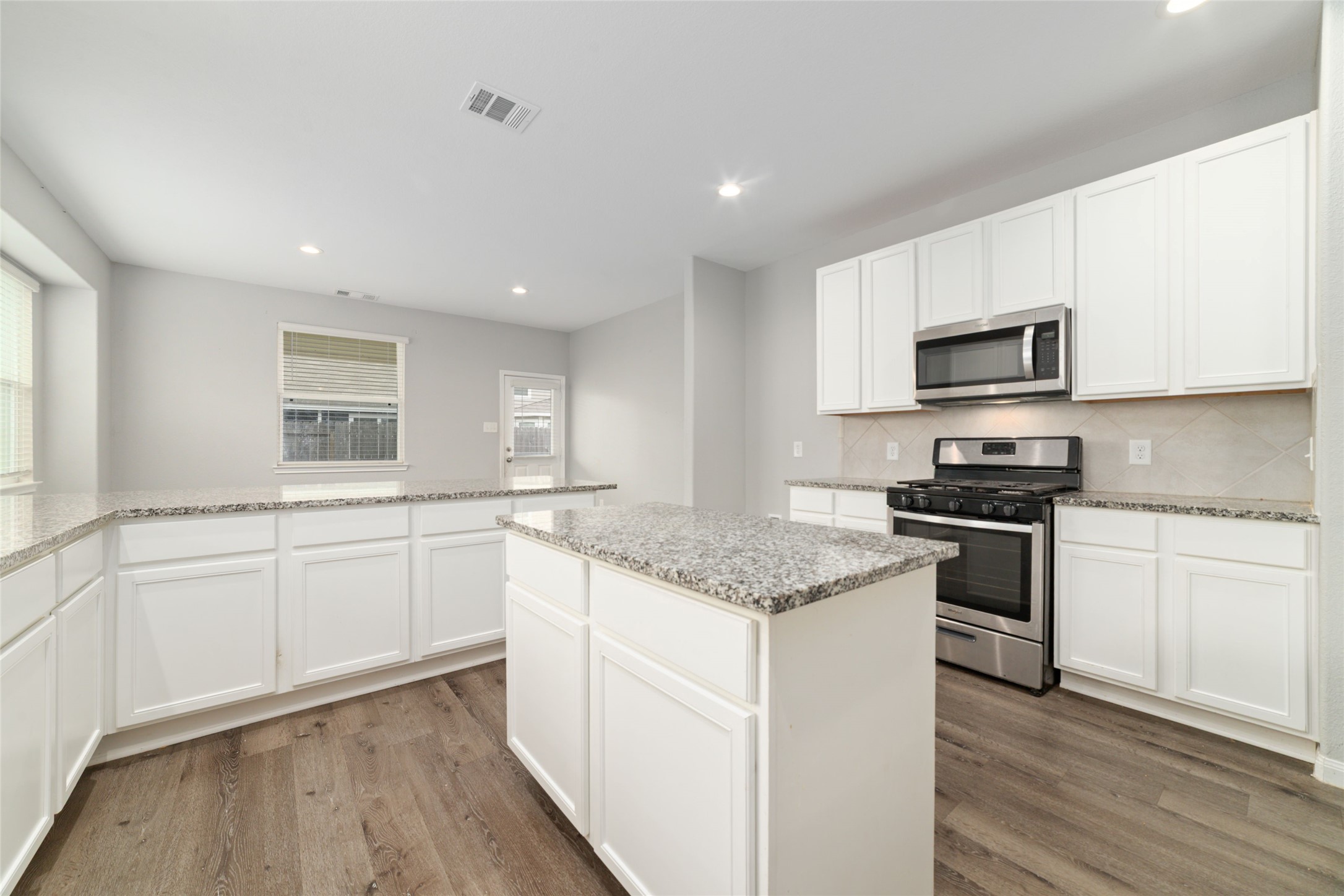 2209 Raider Drive Conroe, TX 77301 - Photo 9 of 27 a kitchen with granite countertop white cabinets and stainless steel appliances