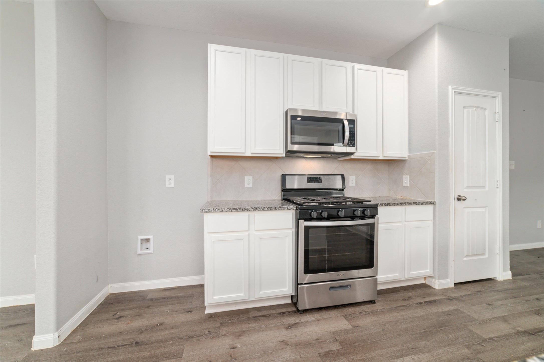 2209 Raider Drive Conroe, TX 77301 - Photo 10 of 27 a kitchen with stainless steel appliances white cabinets and a stove top oven