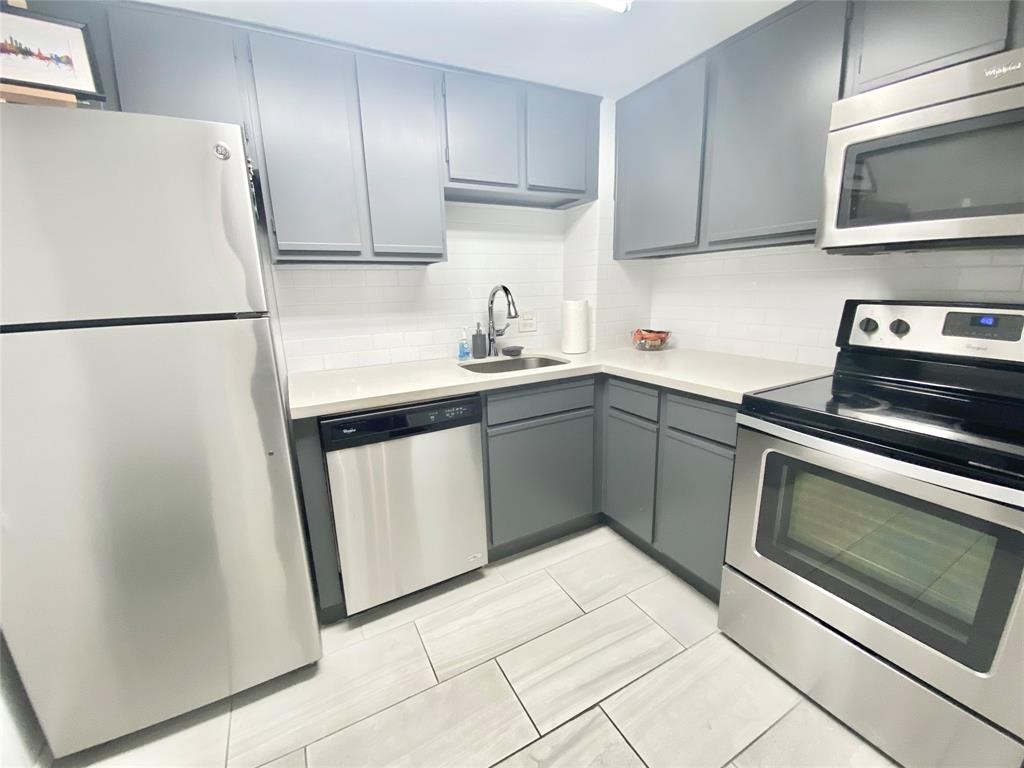 a kitchen with a sink appliances and cabinets