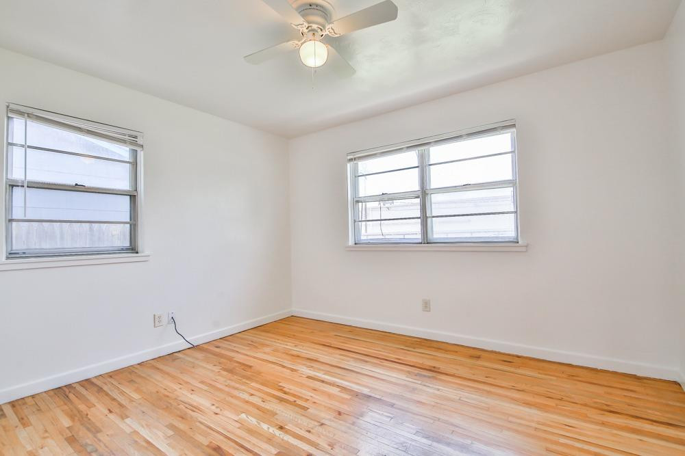 4418 33rd Street Lubbock, TX 79410 - Photo 11 of 21 a view of empty room with wooden floor and fan