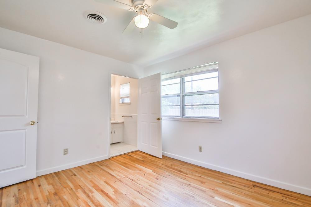 4418 33rd Street Lubbock, TX 79410 - Photo 14 of 21 a view of empty room with wooden floor and fan