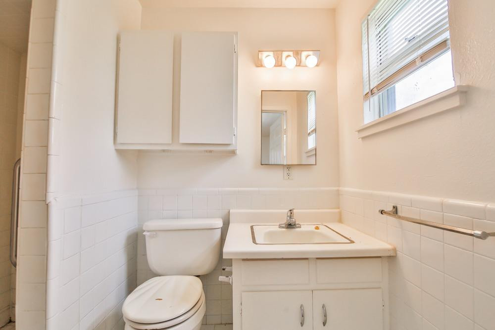 4418 33rd Street Lubbock, TX 79410 - Photo 15 of 21 a bathroom with a toilet sink and mirror