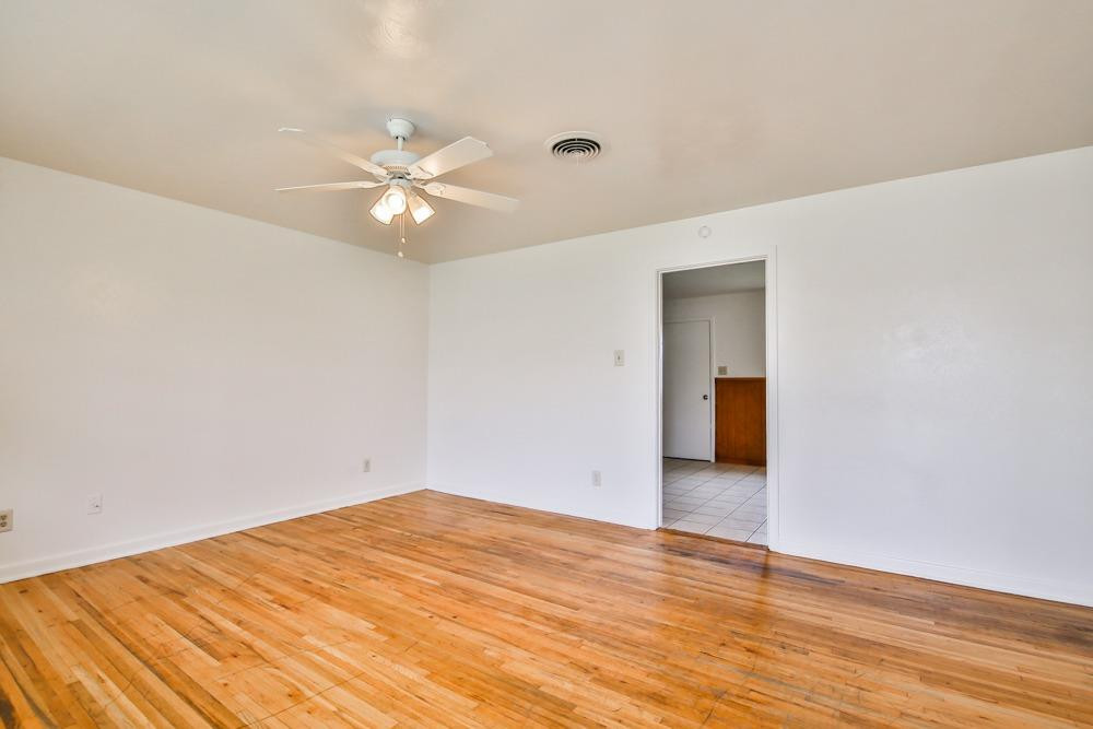 4418 33rd Street Lubbock, TX 79410 - Photo 6 of 21 a view of a big room with wooden floor and a chandelier fan