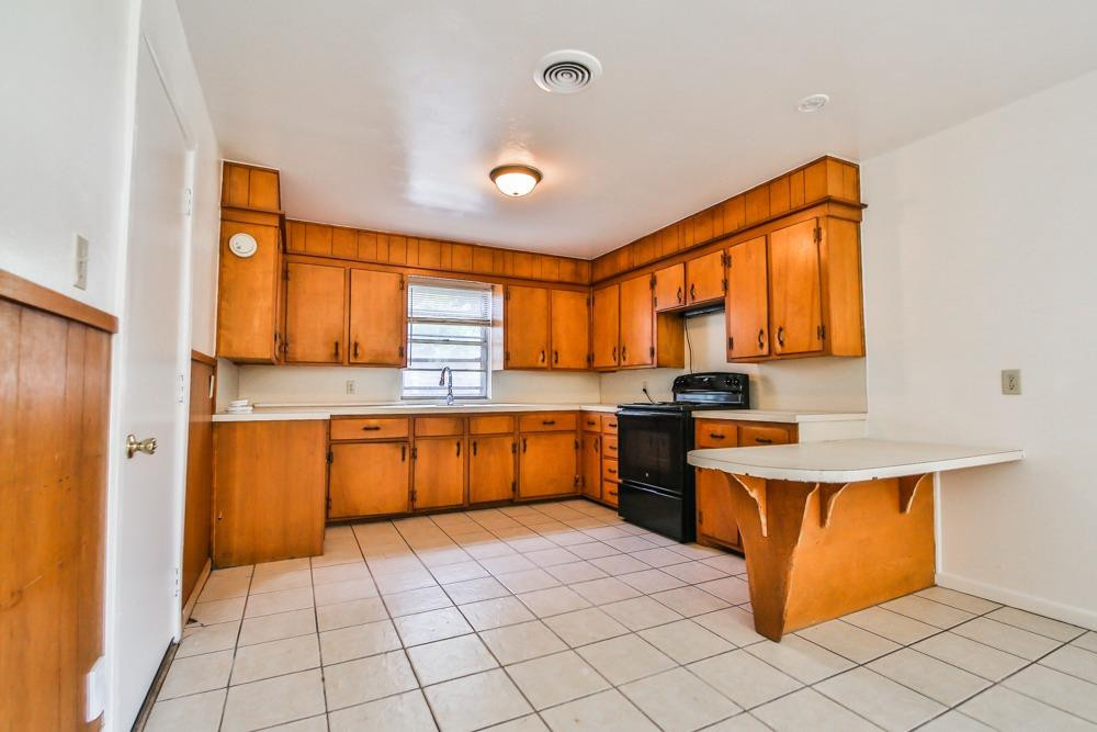 4418 33rd Street Lubbock, TX 79410 - Photo 7 of 21 a large kitchen with a sink stainless steel appliances and cabinets