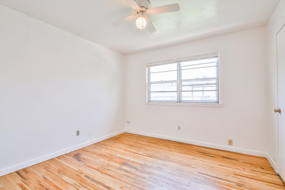 4418 33rd Street Lubbock, TX 79410 - Photo 9 of 21 an empty room with wooden floor fan and windows