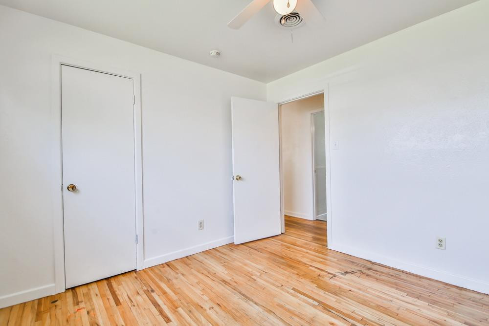 4418 33rd Street Lubbock, TX 79410 - Photo 10 of 21 a view of an empty room with wooden floor