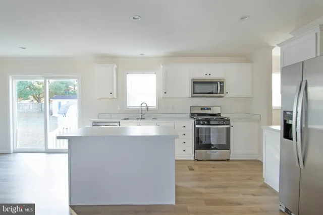 a kitchen with stainless steel appliances a stove a sink and a refrigerator