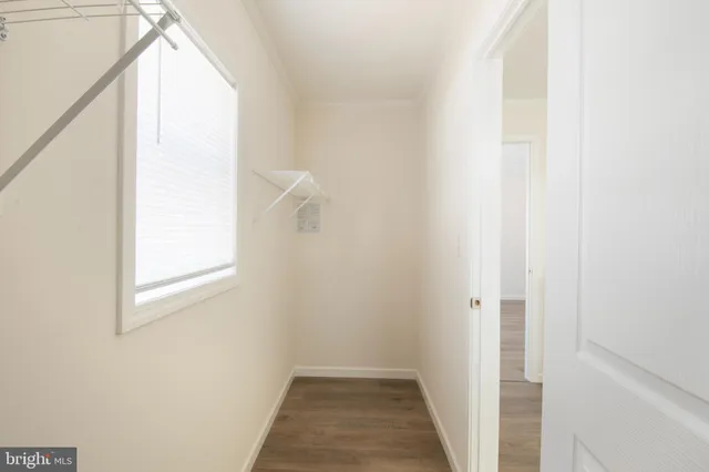 a view of a hallway with wooden floor and a window