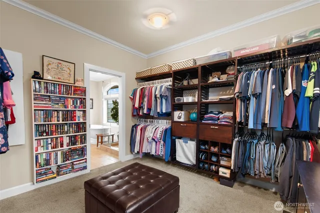 a view of walk in closet with clothes and shoes