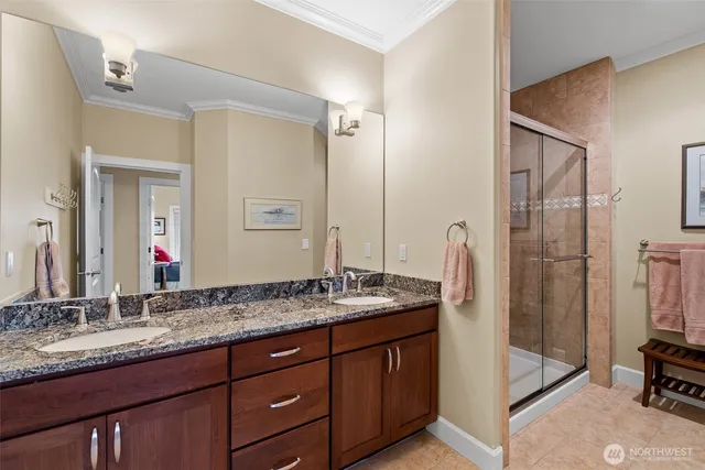 a bathroom with a granite countertop double vanity sink and a mirror