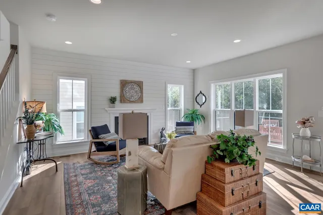 a living room with furniture a fireplace and a potted plant