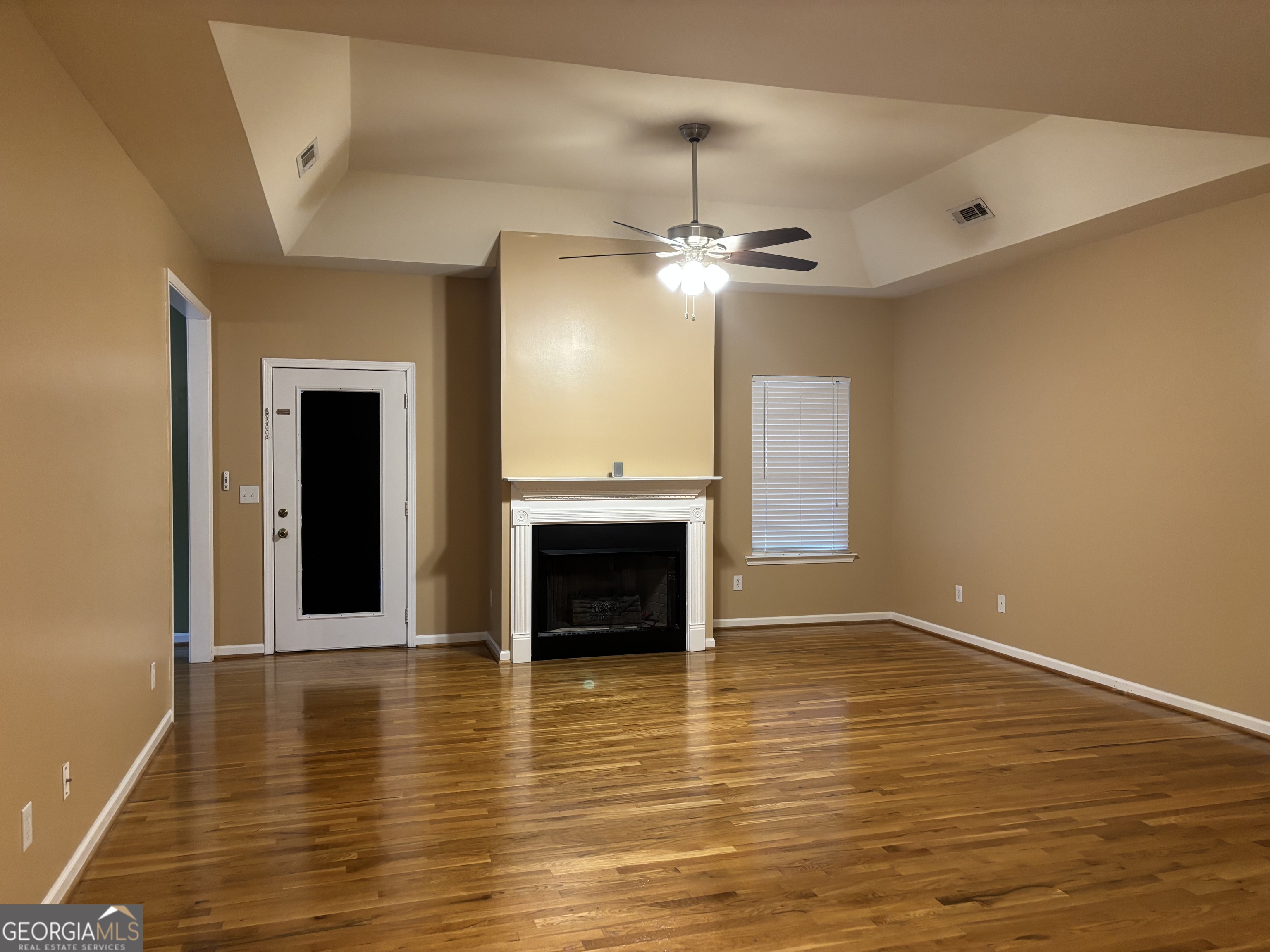 63 Highlander Trail Southwest Rome, GA 30165 - Photo 3 of 49 an empty room with wooden floor fireplace and chandelier