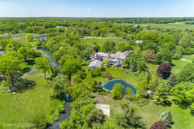 an aerial view of a house with outdoor space and lake view