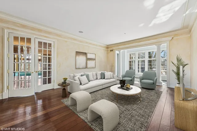 a dining room with furniture a chandelier and wooden floor
