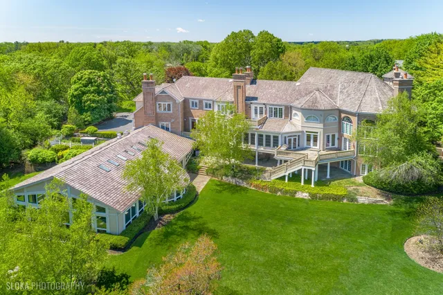 a living room with furniture fireplace and large windows