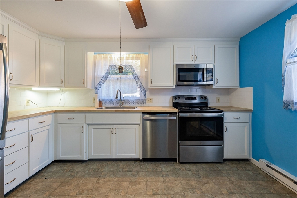 3 Henry Street Chicopee, MA 01020 - Photo 13 of 31 a kitchen with granite countertop white cabinets and stainless steel appliances