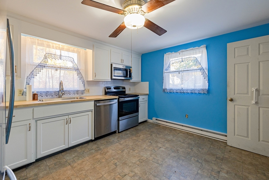 3 Henry Street Chicopee, MA 01020 - Photo 15 of 31 a kitchen with granite countertop a stove a sink and a window