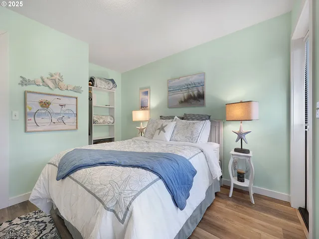 a bedroom with a bed and a lamp on dresser