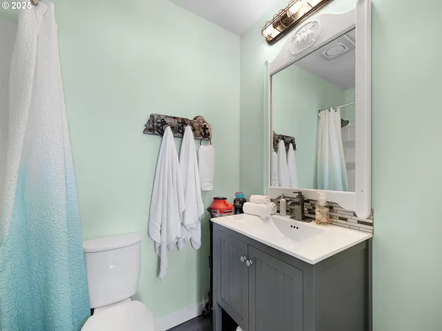 a bathroom with a sink vanity mirror and toilet