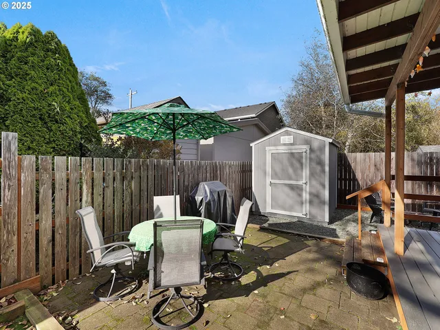 a view of a patio with table and chairs with wooden fence and plants