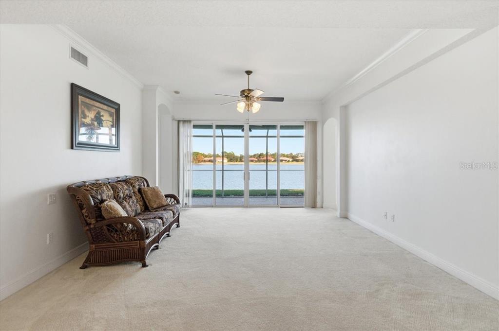 6515 Moorings Point Circle, Unit 102 Lakewood Ranch, FL 34202 - Photo 13 of 52 a living room with furniture and a chandelier