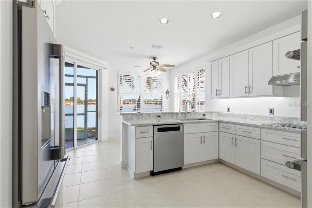 6515 Moorings Point Circle, Unit 102 Lakewood Ranch, FL 34202 - Photo 13 of 61 a kitchen with granite countertop a sink and cabinets