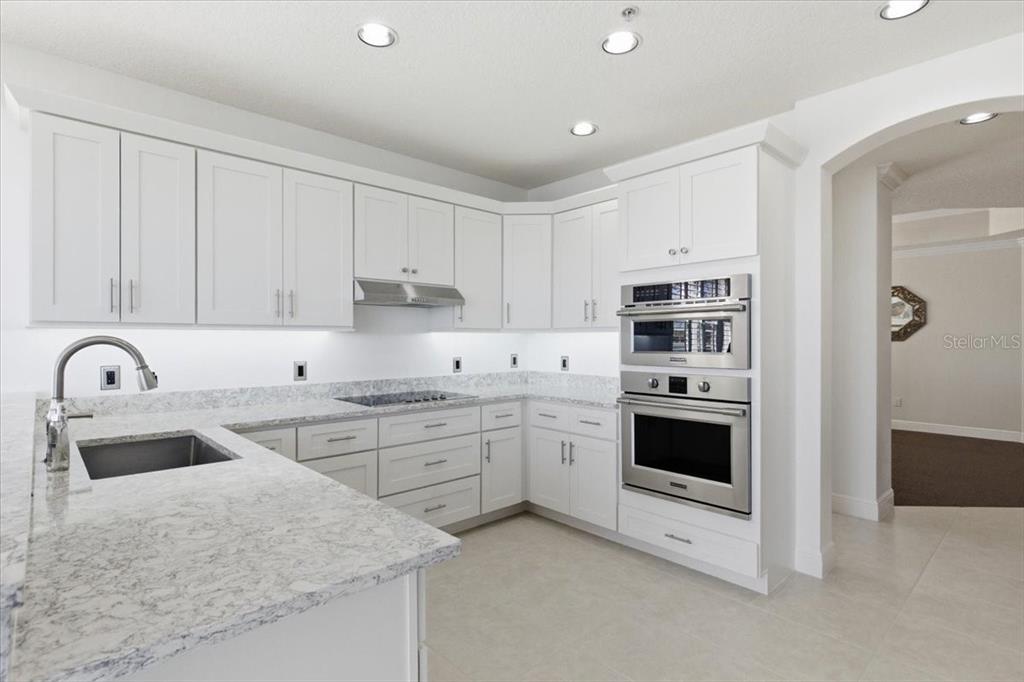 6515 Moorings Point Circle, Unit 102 Lakewood Ranch, FL 34202 - Photo 14 of 61 a kitchen with granite countertop a sink stainless steel appliances and cabinets