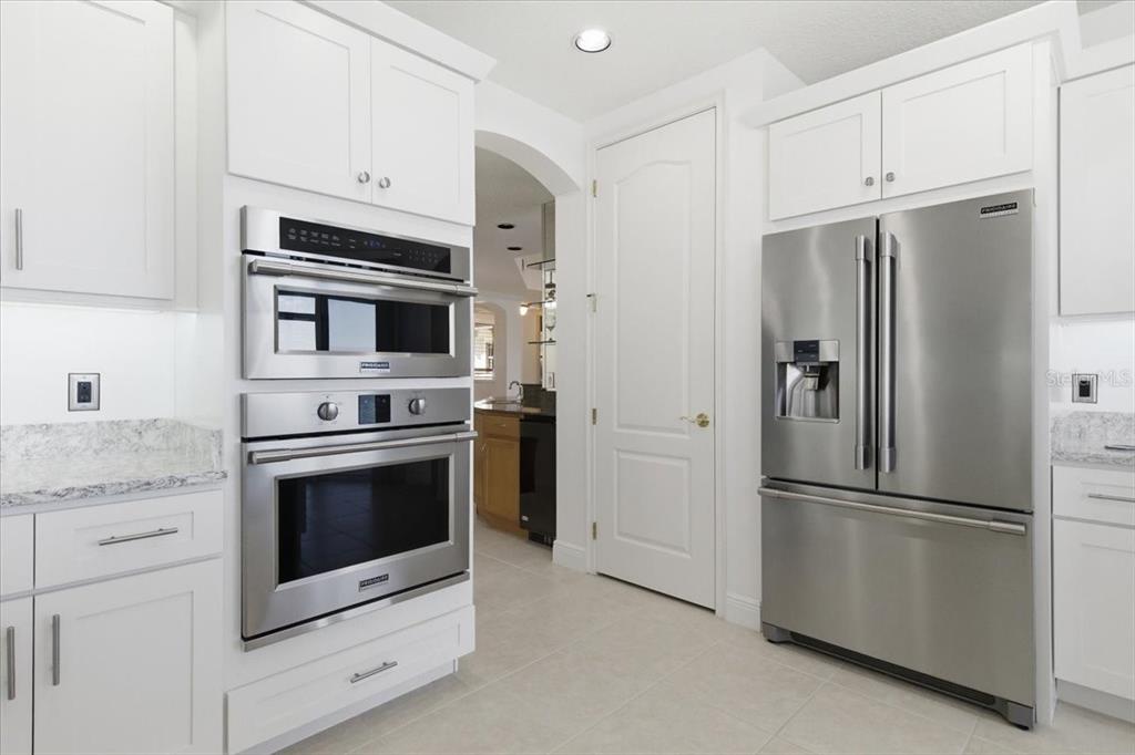 6515 Moorings Point Circle, Unit 102 Lakewood Ranch, FL 34202 - Photo 16 of 61 a kitchen with stainless steel appliances white cabinets white stove a refrigerator and a microwave