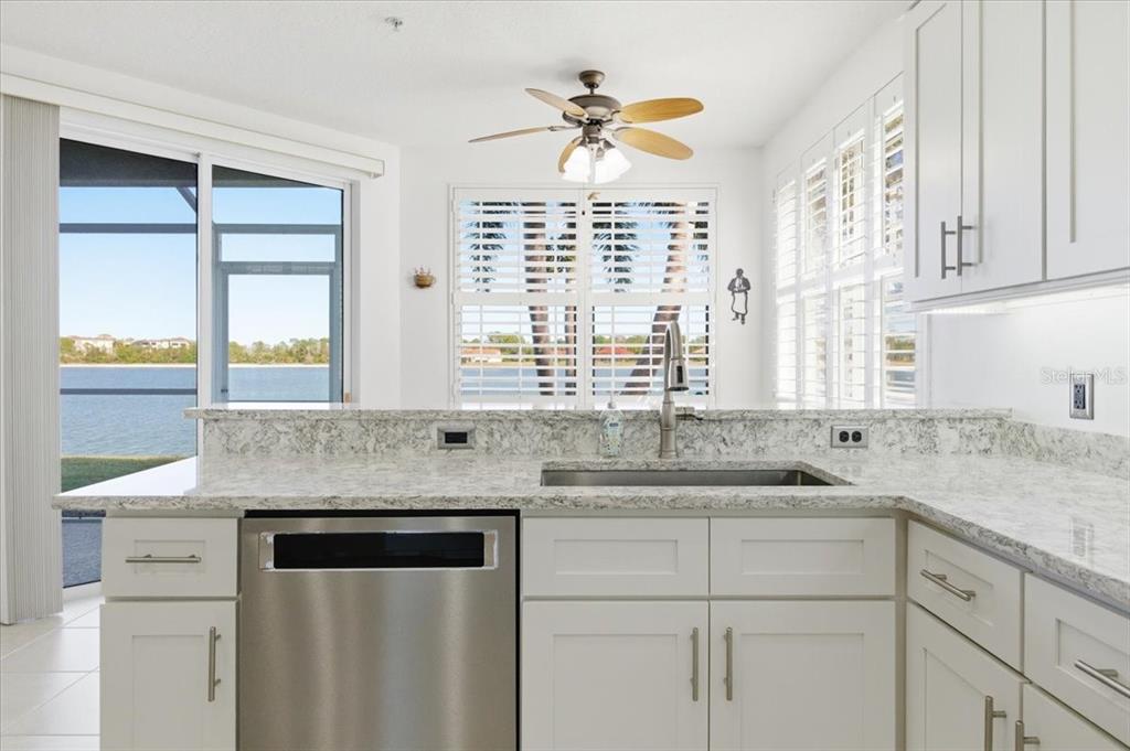 6515 Moorings Point Circle, Unit 102 Lakewood Ranch, FL 34202 - Photo 18 of 52 a kitchen with granite countertop a sink window and cabinets