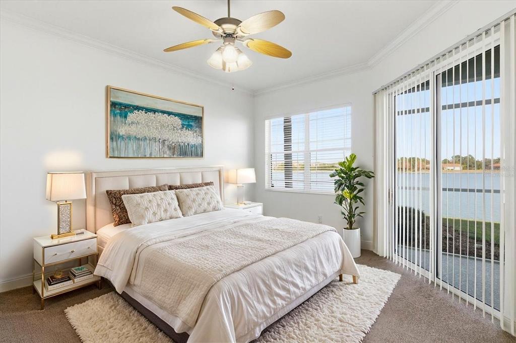 6515 Moorings Point Circle, Unit 102 Lakewood Ranch, FL 34202 - Photo 23 of 61 a bedroom with a bed and a chandelier