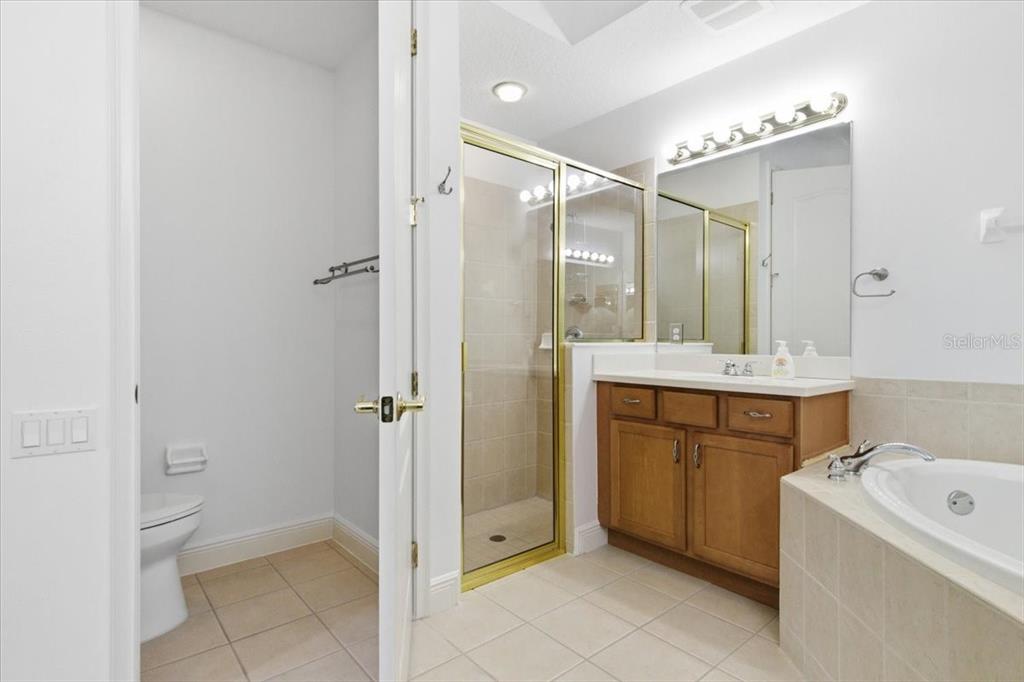 6515 Moorings Point Circle, Unit 102 Lakewood Ranch, FL 34202 - Photo 32 of 52 a bathroom with a granite countertop sink mirror and bathtub